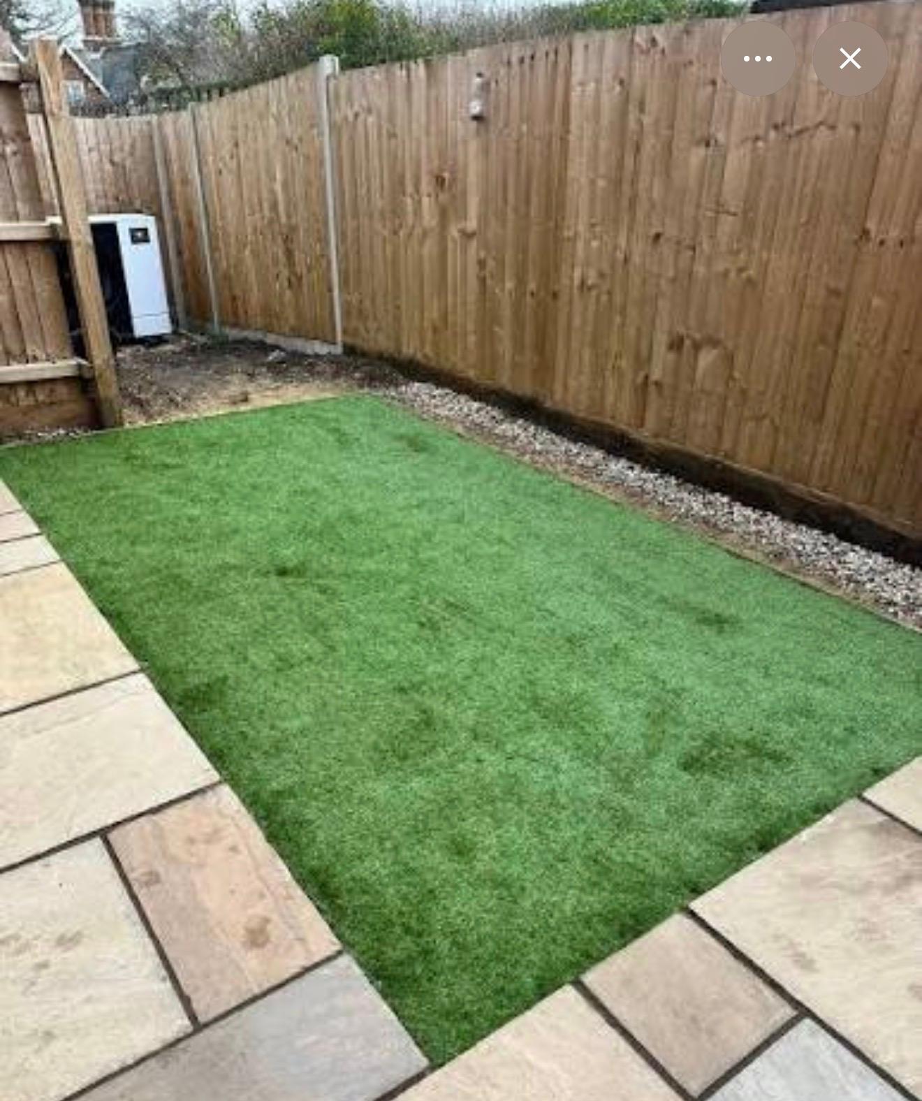 Artificial grass garden with sandstone patio and close-board timber fencing