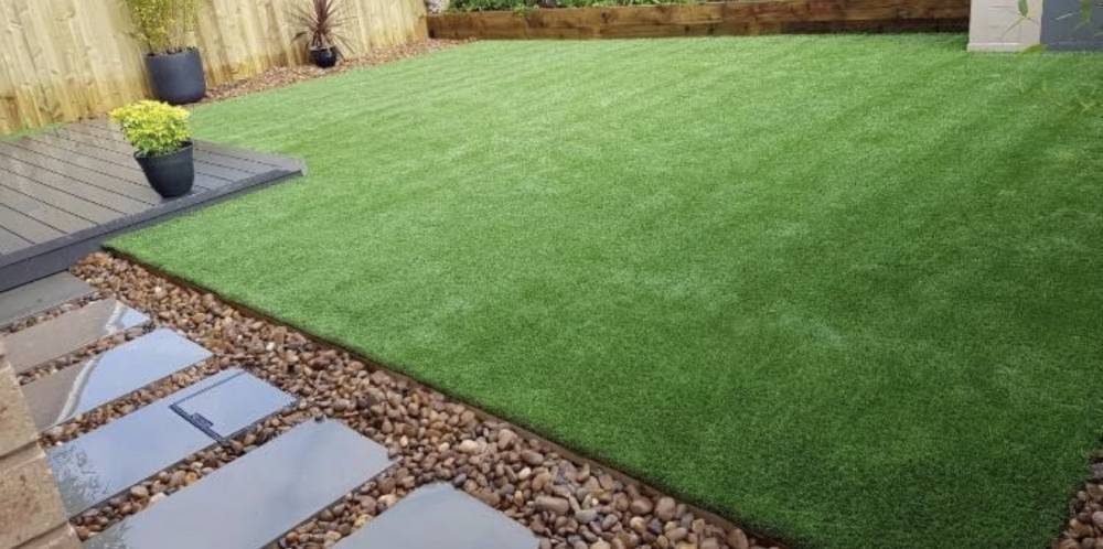 Artificial grass with stepping stone path and pebble border