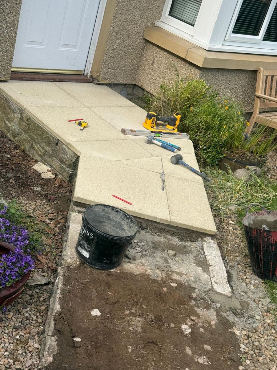 Buff paving slabs being laid for a front path and step