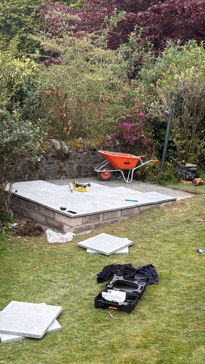 Granite slabs being laid on a raised greenhouse base
