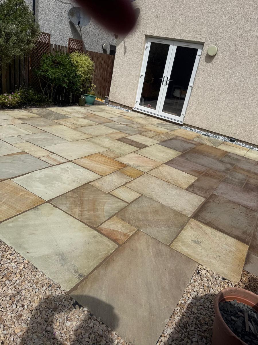 Indian sandstone patio outside French doors with gravel border