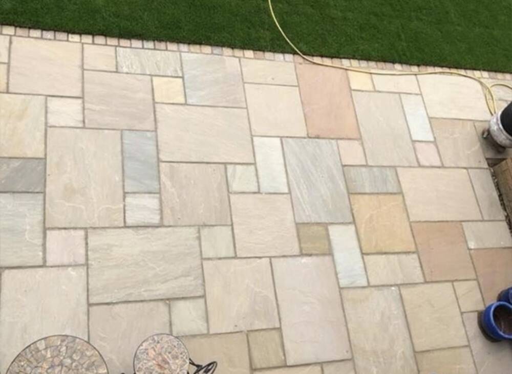 Indian sandstone patio path along side of house with sleeper edging