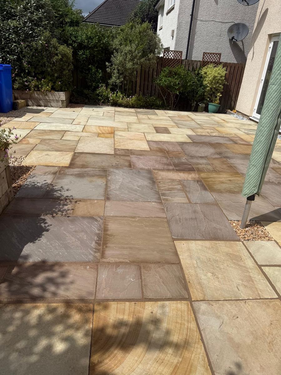 Indian sandstone patio with mixed-size slabs and gravel surround