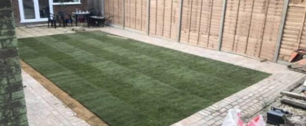 New turf lawn with patio surround and close-board fencing
