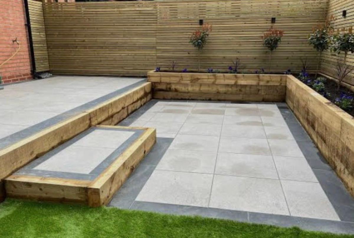 Porcelain patio with sleeper raised beds and slatted fence