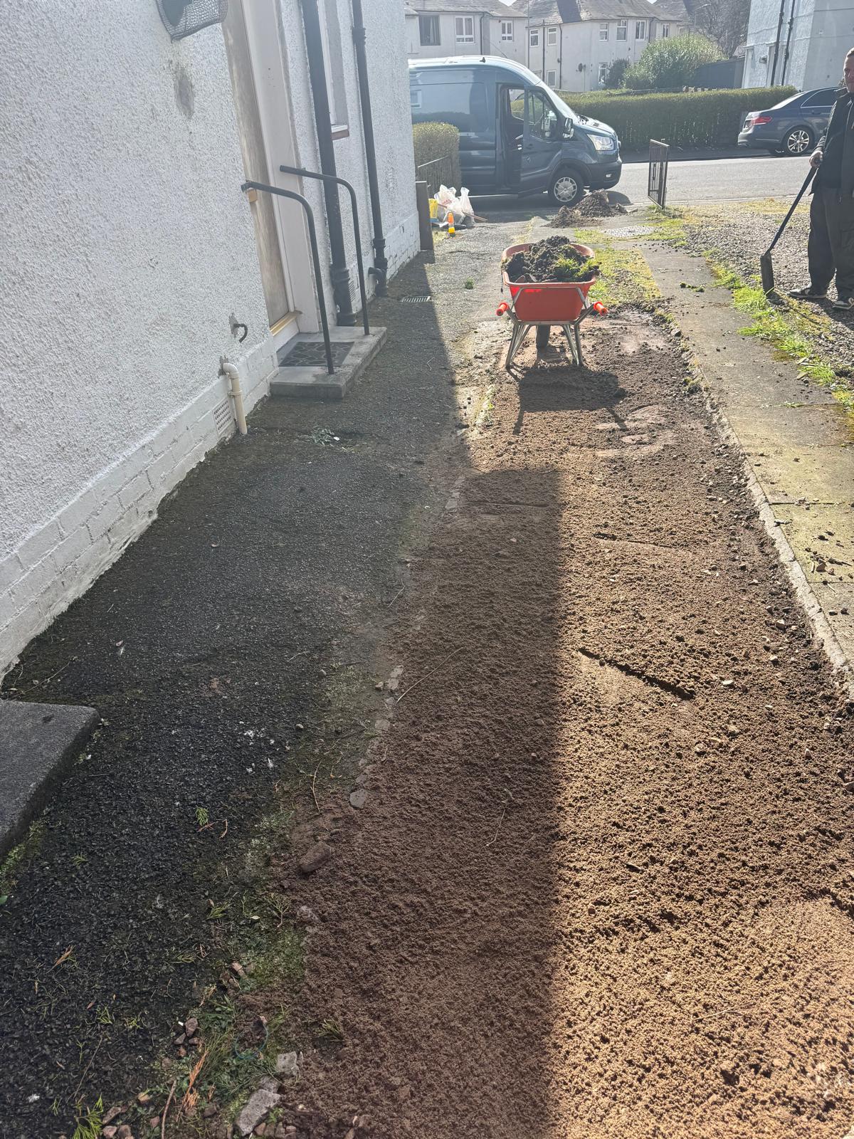 Side path ground preparation with wheelbarrow during landscaping