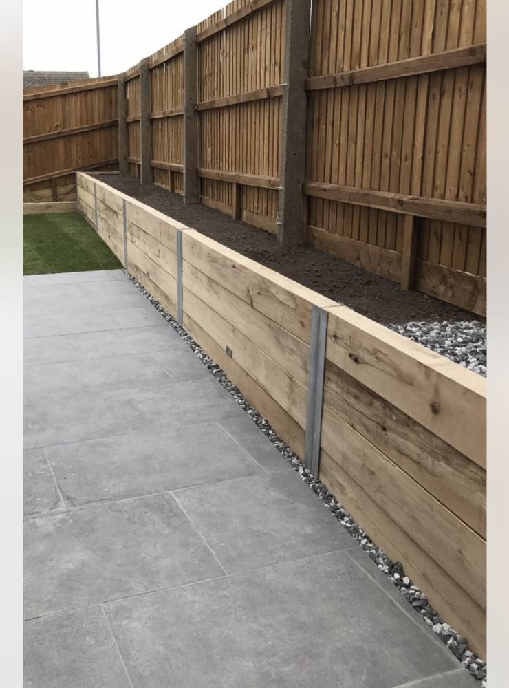 Sleeper raised bed with porcelain paving and timber fencing