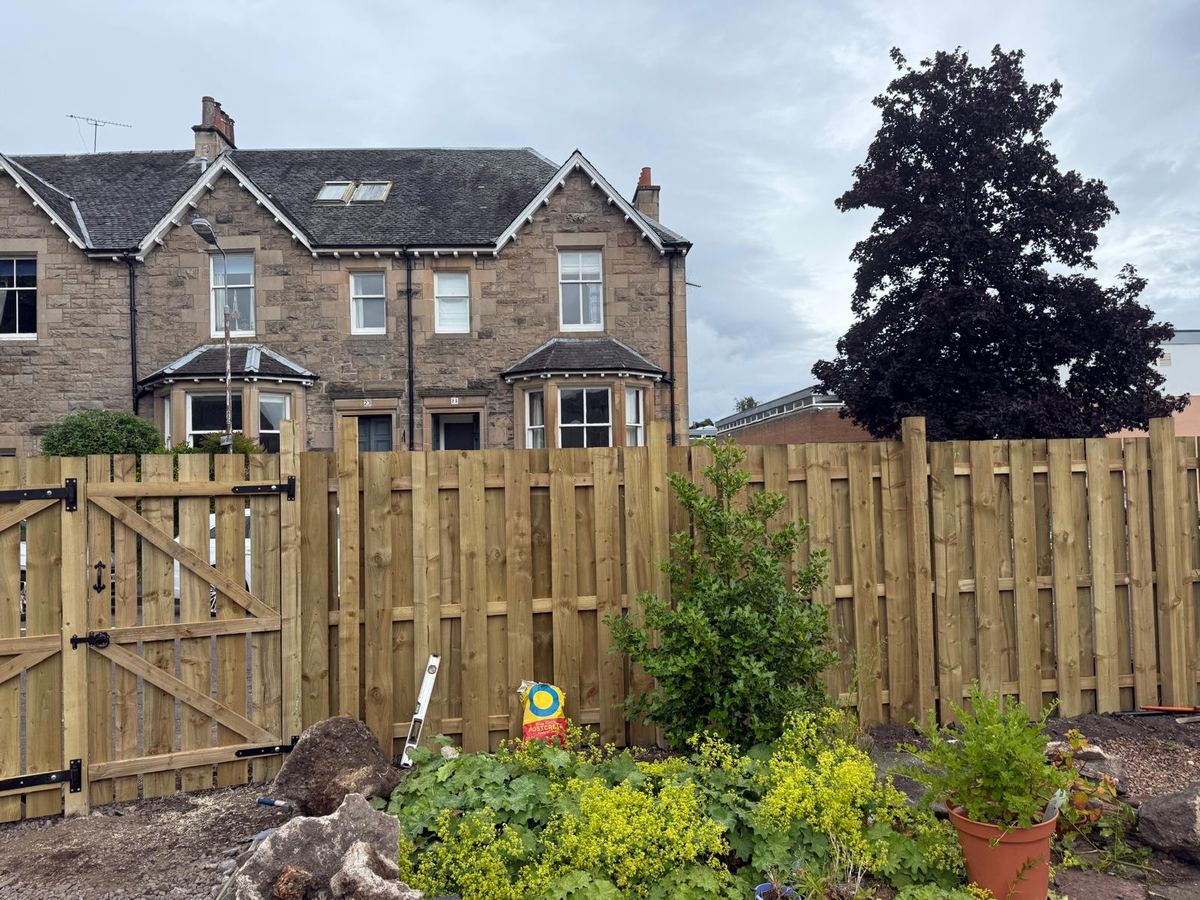 Timber fence and pedestrian gate around a garden