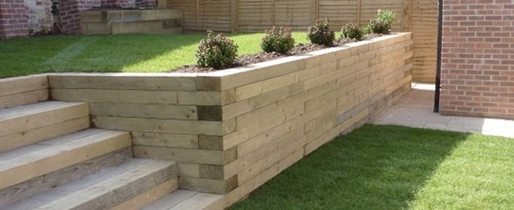 Timber sleeper retaining wall with built-in steps and fresh turf